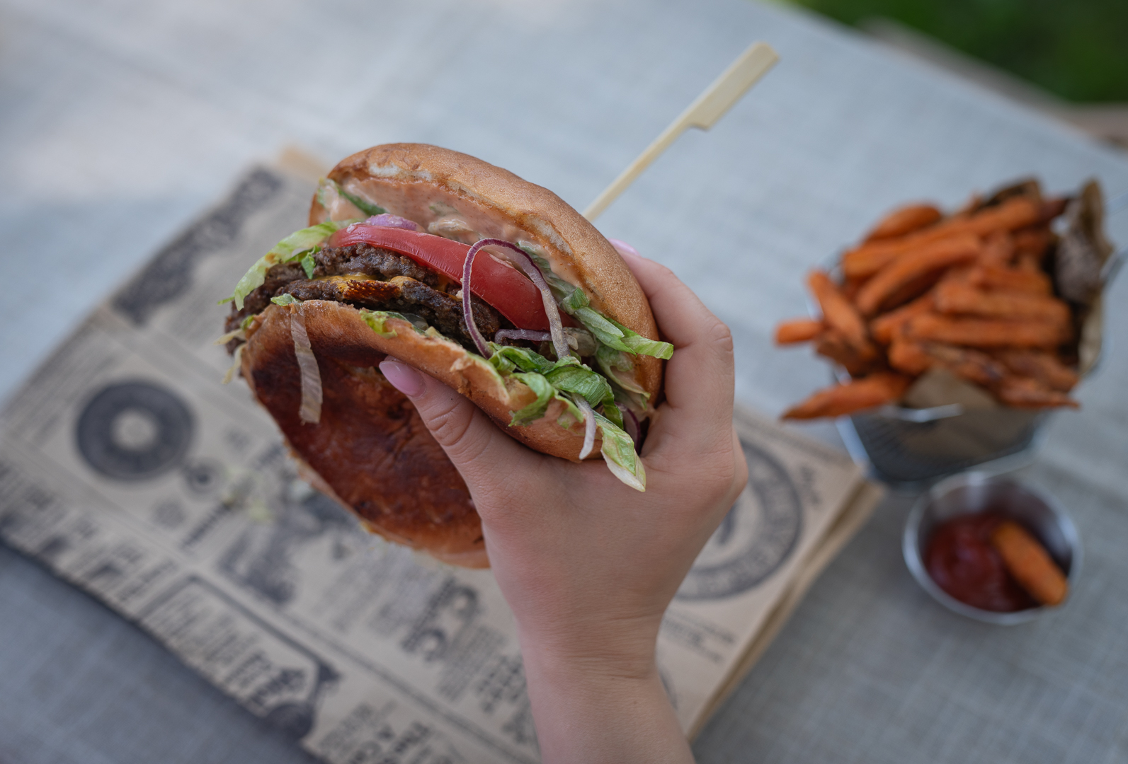 Burger SMASH trzymany w dłoni